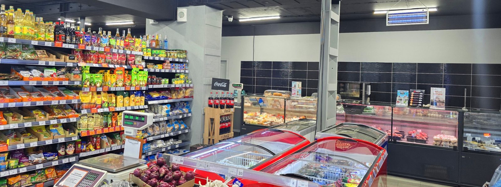 Interior de una tienda Gryadka con estanterías abastecidas y refrigeración